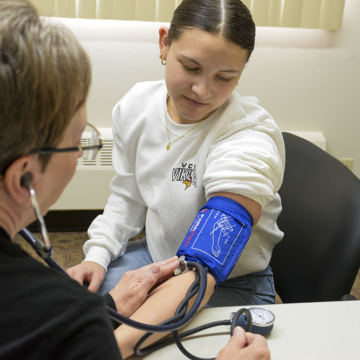 nurse taking student's blood pressure